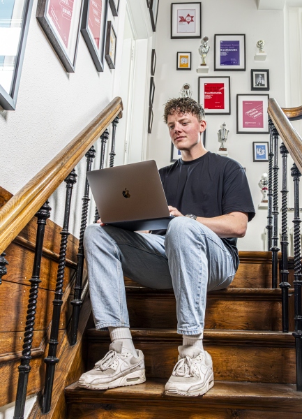 Persoon zit op de trap te werken